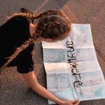 Girl looking at a map while lying on the street